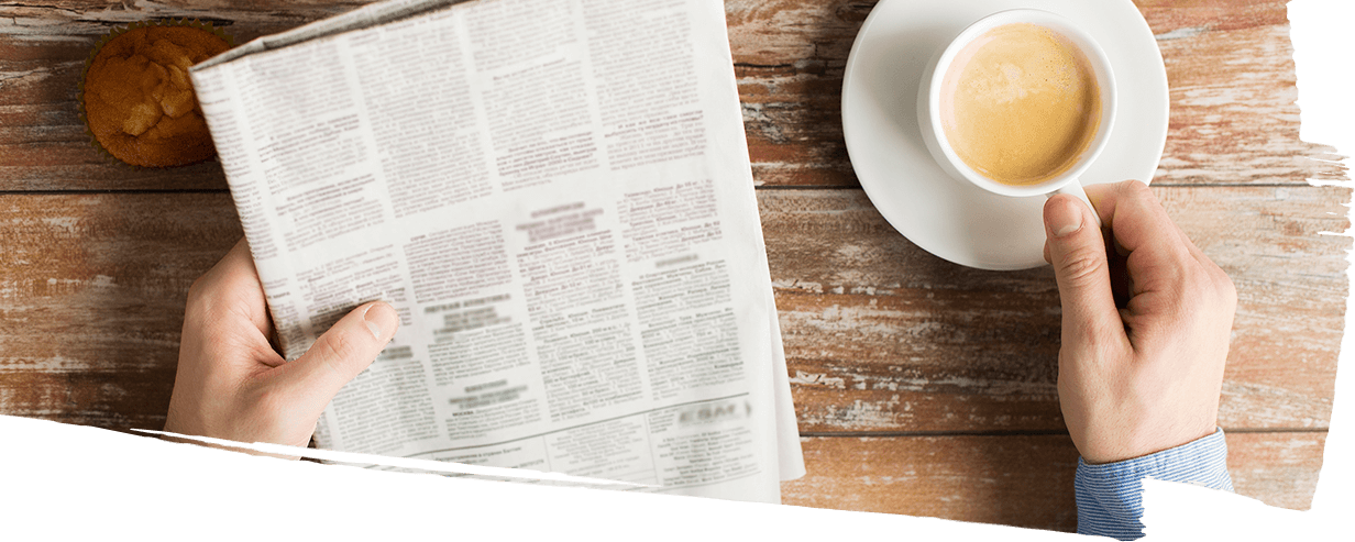 Man enjoying espresso while reading the newspaper