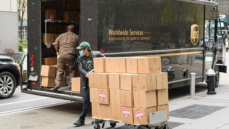 UPS delivery vehicle and busy worker in the city during COVID times