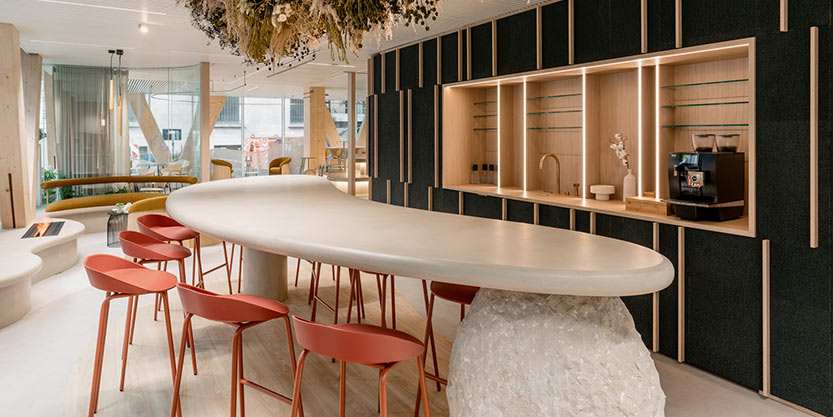Modern office space with red stool, wood accents