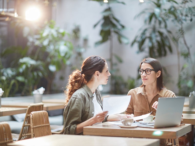 Two Young Businesswomen in Cafe