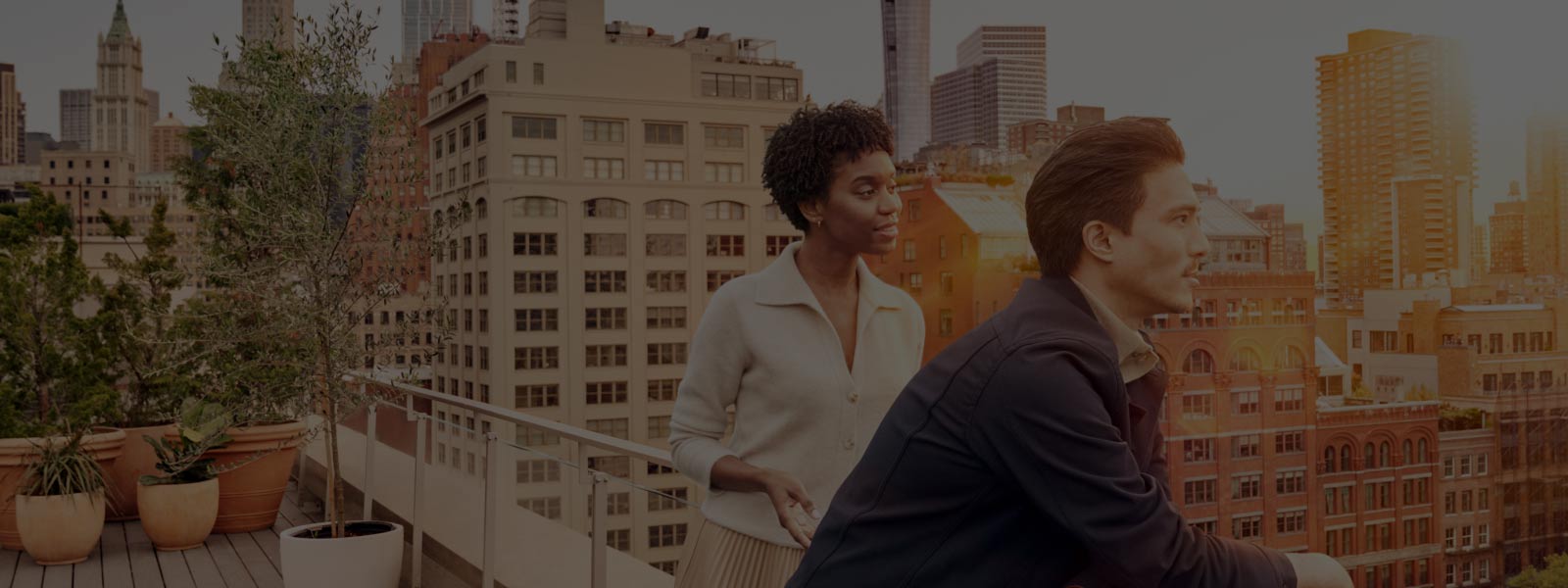 A guy and a lady standing on the roof and seeing the view from the building