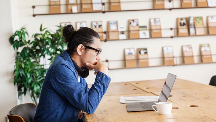 JLL employee attending online meeting with a cup of coffee