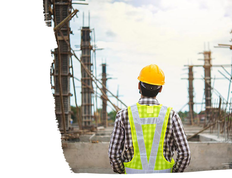 A worker in front of a construction site