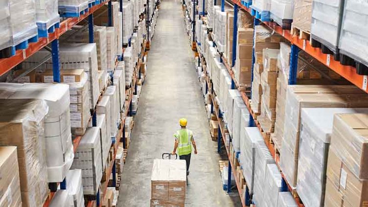worker passing in the large warehouse aisle